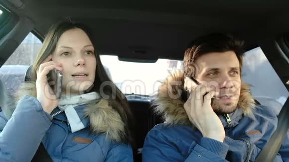 男人和女人说着手机坐在车里微笑前景视频的预览图