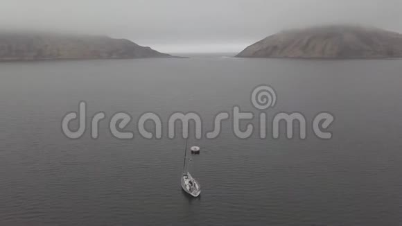 白色游艇停泊在蓝色的海面上的山景空中视频的预览图
