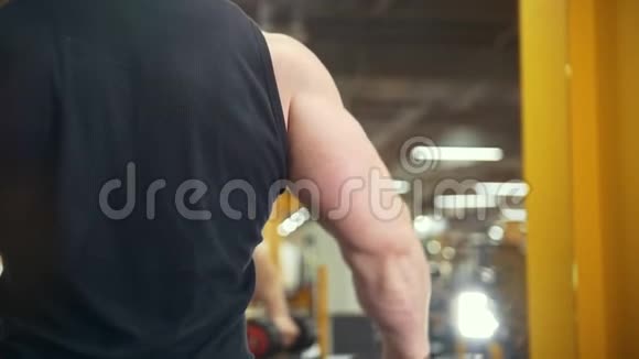 肌肉男在健身房举起哑铃后视视频的预览图