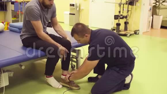 康复中心的医生给残疾人穿上鞋子视频的预览图