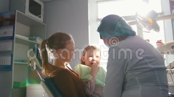 在牙医接待的女孩口腔医生检查了孩子牙齿淘气的女孩微笑着视频的预览图