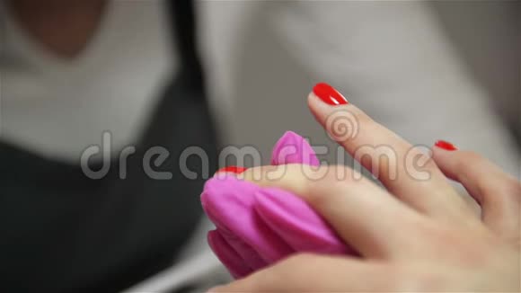 一位在美容院修指甲的女士可以近距离观看一位美容师用涂抹器涂抹清漆视频的预览图