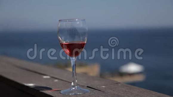 一个年轻漂亮的女人从玻璃酒杯里喝红酒望着大海一个穿着晚礼服的女人骑着视频的预览图
