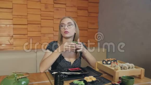 坐在日本餐馆喝茶的年轻女子视频的预览图