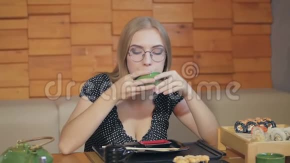 坐在日本餐馆喝茶的年轻女子视频的预览图