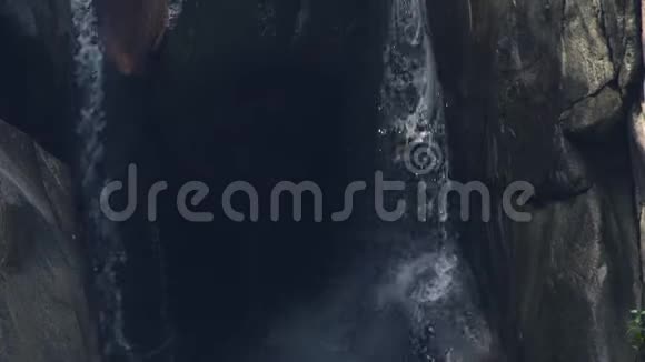 瀑布溅在山林中热带丛林中的山瀑布流水流动的石河视频的预览图