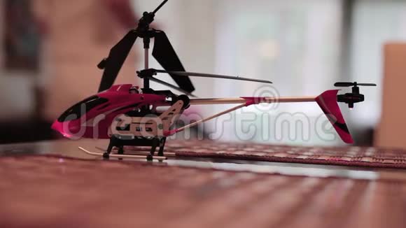 镜头显示玩具直升机在桌子上金发跑到阳台然后挥动手视频的预览图