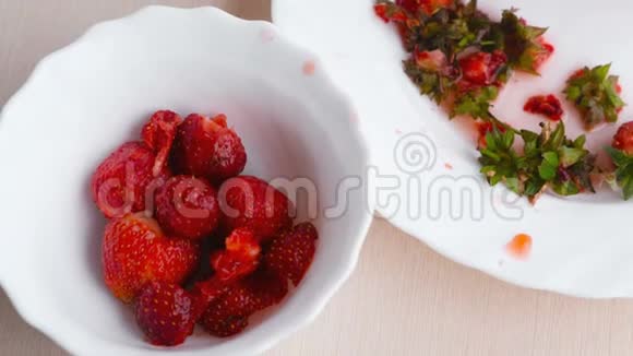女人清洗草莓并把它放在碗里特写女人手视频的预览图