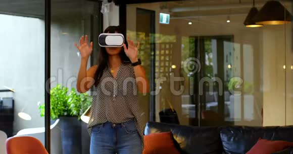 在现代办公室使用虚拟现实耳机的年轻白种人女高管的正面看法视频的预览图