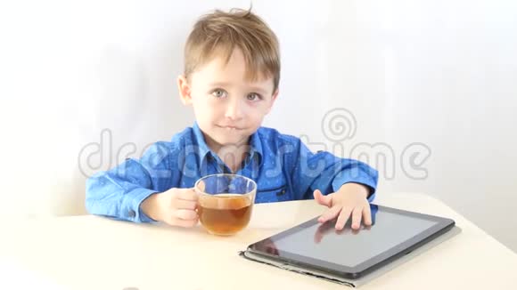 一个孩子正在玩药片休息时喝茶互联网和无线技术儿童的概念视频的预览图