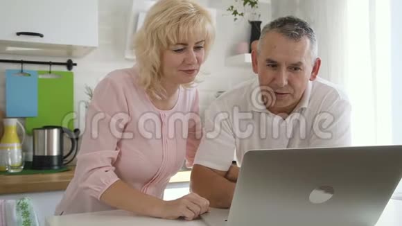 幸福老人家庭在公寓厨房使用电脑视频的预览图