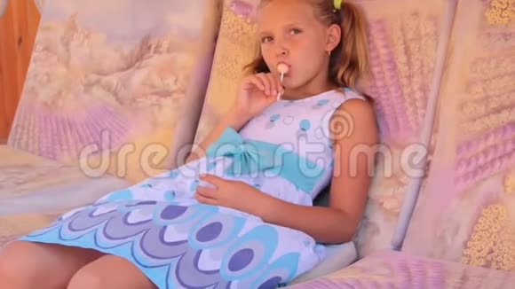 小女孩在秋千上带着糖果夏天视频的预览图
