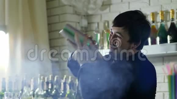 盖伊巴曼手里拿着摇床把配料混合在烟的背景瓶上视频的预览图