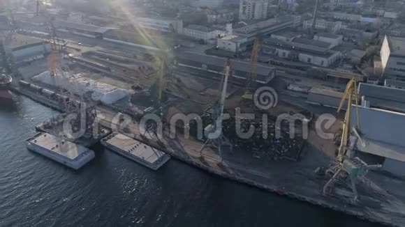 带有背光起重机的货港工业船和金属堆的无人机视图可供运输视频的预览图