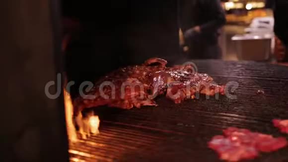 肉在一个大烤架里煎在巨大的旋转网格上烤火的排骨视频的预览图