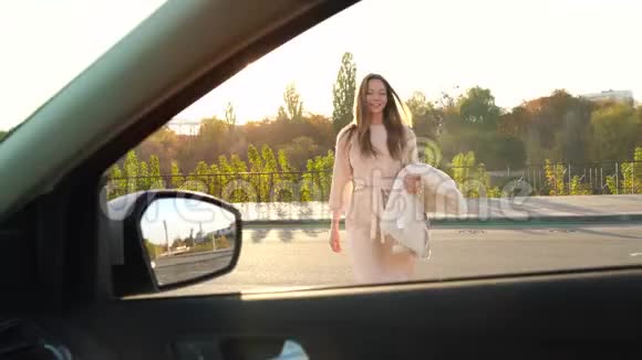 美丽的女孩把外套放在汽车座椅上上了车系好安全带就要开走了视频的预览图