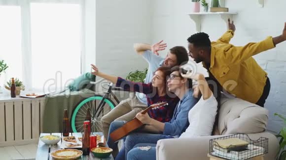 多个民族的快乐朋友在玩啤酒的时候在智能手机摄像头上自拍视频的预览图