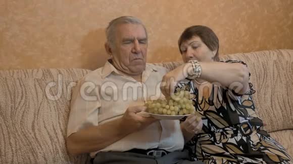 一位年老的妇女给丈夫喂葡萄他们是一对幸福的夫妇视频的预览图