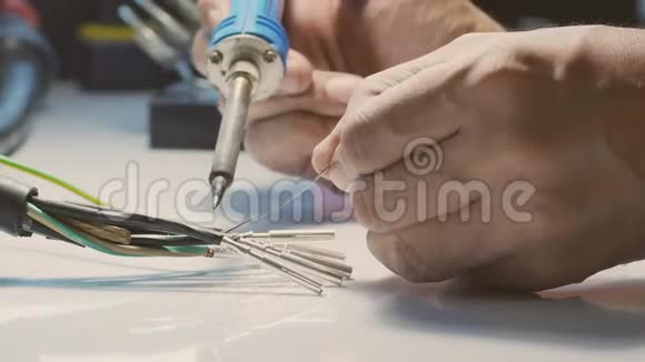 电工们用电烙铁把电线和金属针连起来视频的预览图