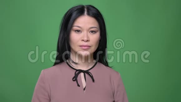 年轻迷人的亚洲女性特写镜头黑发直视镜头背景被隔离视频的预览图