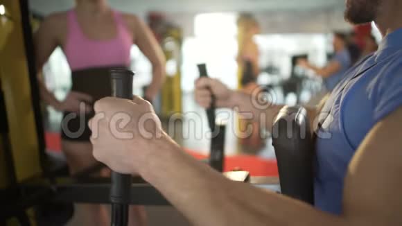 男人在健身房锻炼吸引美女的注意调情视频的预览图