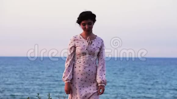 可爱的白种人布吕内特女孩在海上悬崖轻装的肖像欣赏日出时间视频的预览图