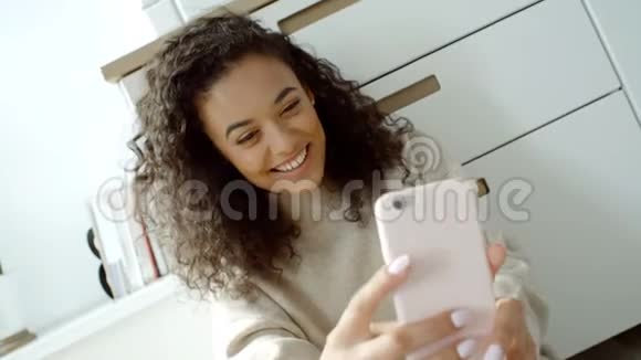 年轻女子在厨房用手机自拍视频的预览图
