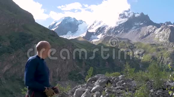 一个人站在山峰前用手指着它们视频的预览图