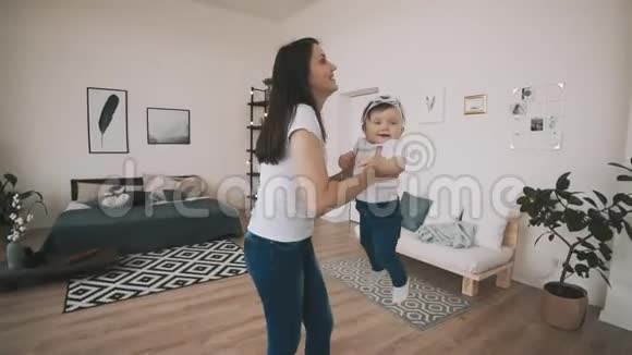 年轻的妈妈和女儿在慢动作中玩得很开心妈妈把小宝宝扔了视频的预览图