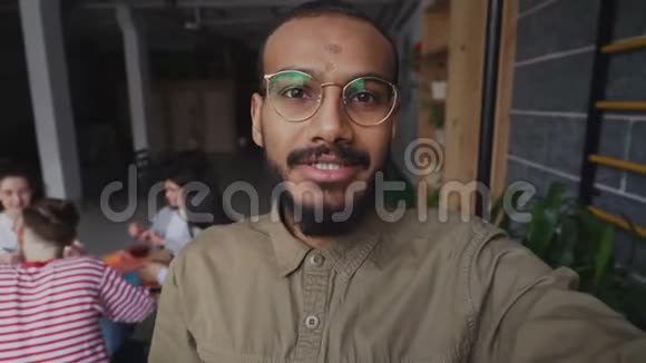 一位戴着智能手机眼镜的非裔美国嬉皮士男士的特写镜头他的同事还在现场视频通话视频的预览图