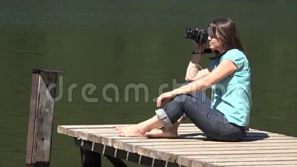 有魅力的女人在大自然中拍照专业的相机美丽的爱好视频的预览图