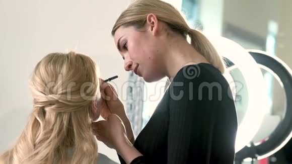 化妆师用画笔将眼影涂于脸部特写视频的预览图