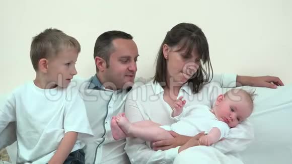 妈妈抱着宝宝和爸爸抱着大哥哥家人享受新成员视频的预览图