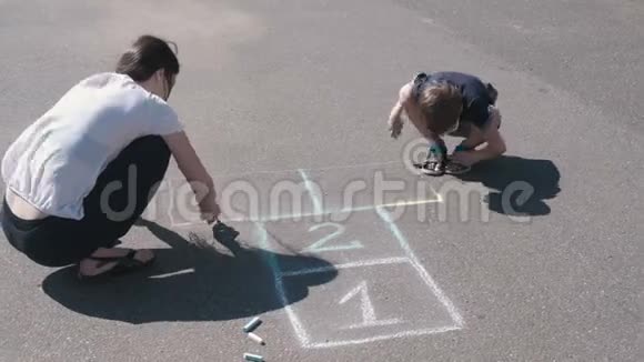 母亲和儿子一起在人行道上画跳房子视频的预览图