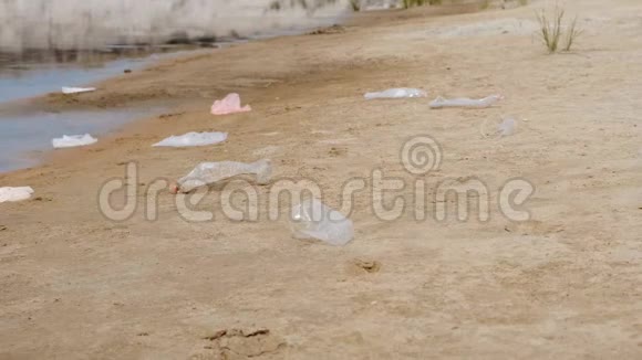 塑料瓶袋子和其他垃圾倾倒在海滩的沙子和干涸的河流湖泊中视频的预览图