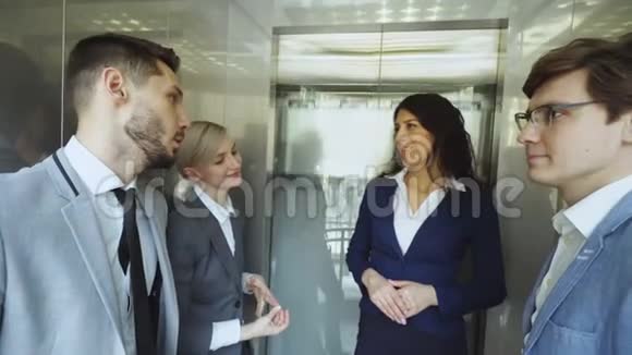 跟踪女商人和女商人同事在移动电梯中交谈的镜头然后从电梯里出来走进来视频的预览图