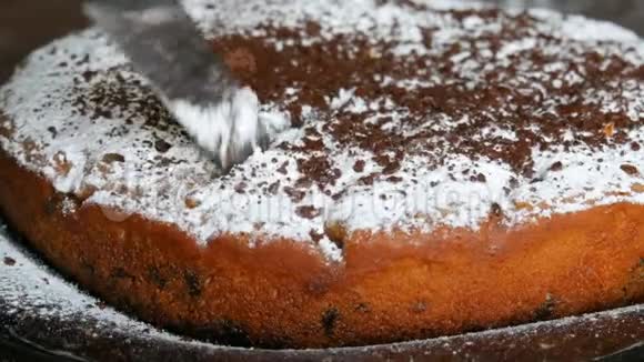 刀切了一块美味的新鲜烤樱桃蛋糕上面有糖粉和磨碎的巧克力片家庭烘焙视频的预览图