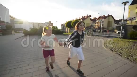 快乐的孩子们一起奔跑牵着手在路上太阳在他们的脸上闪耀视频的预览图
