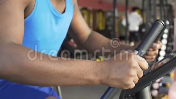 努力工作的男性运动员在健身俱乐部骑固定自行车动力视频的预览图
