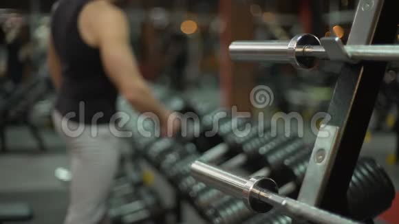 运动型年轻人在健身房做哑铃式举重锻炼身体视频的预览图