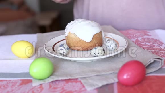 女人用勺子在复活节蛋糕的顶部撒釉桌子上的彩色鸡蛋视频的预览图