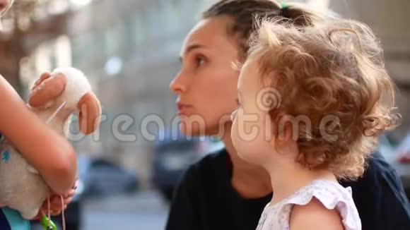 漂亮的年轻母亲和小女儿市夏季温暖日视频的预览图