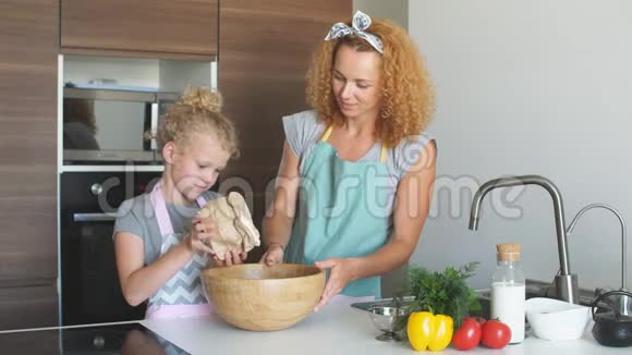 小女孩和她妈妈把面粉洒进碗里一边烤一边笑视频的预览图