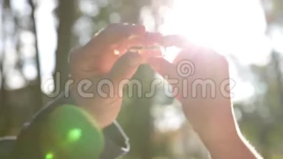 双手握住戒指紧贴太阳光线珍视珠宝或结婚视频的预览图