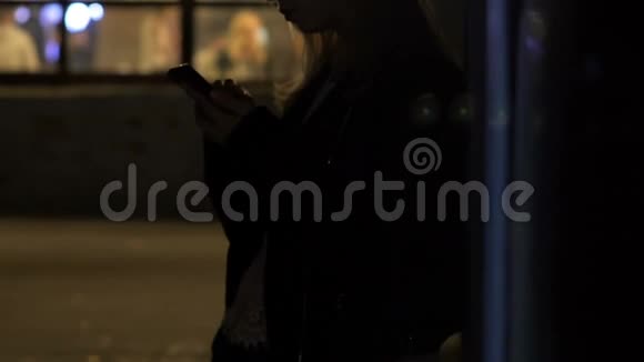 孤独女孩的剪影在户外令人耳目一新在智能手机上拍照视频的预览图