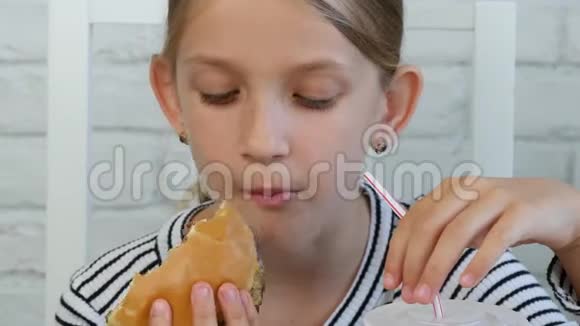 在餐馆吃汉堡的儿童吃垃圾快餐的小女孩视频的预览图