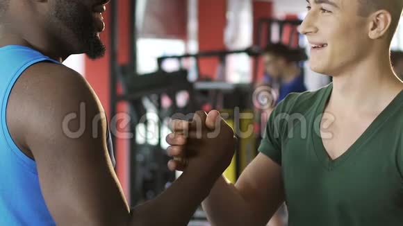 非裔美国人和高加索人在健身房握手国际友谊视频的预览图