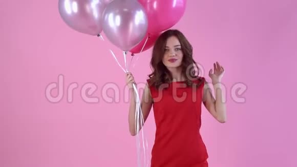 年轻女子工作室与粉红女子隔离今天摆着气球摆姿势视频的预览图