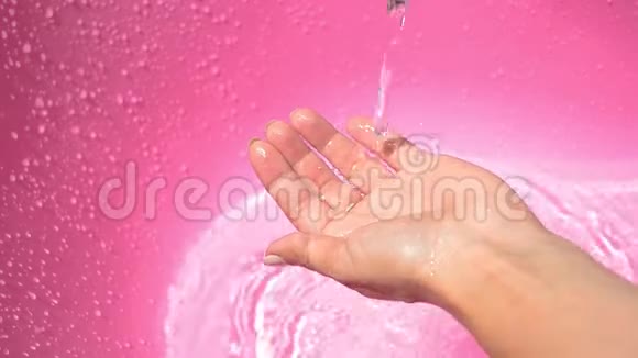 女性的手触摸在粉红色的容器里倒水视频的预览图