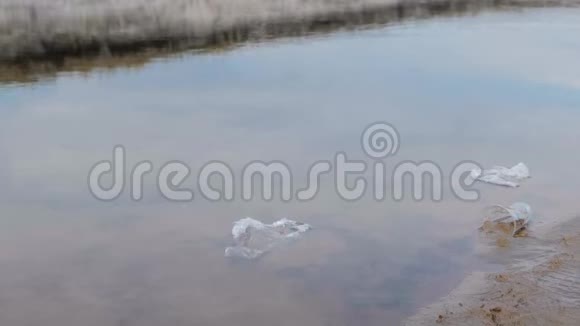 塑料瓶袋子和其他垃圾倾倒在海滩的沙子上和河流湖泊中视频的预览图